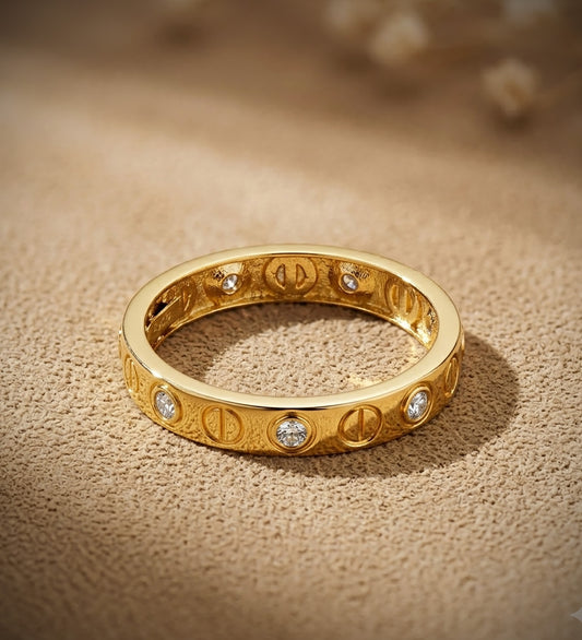 18K SORTIJA ORO AMARILLO CIRCONITAS Y MOTIVO DE TORNILLOS EN BRILLO. ANCHO: 3 MM