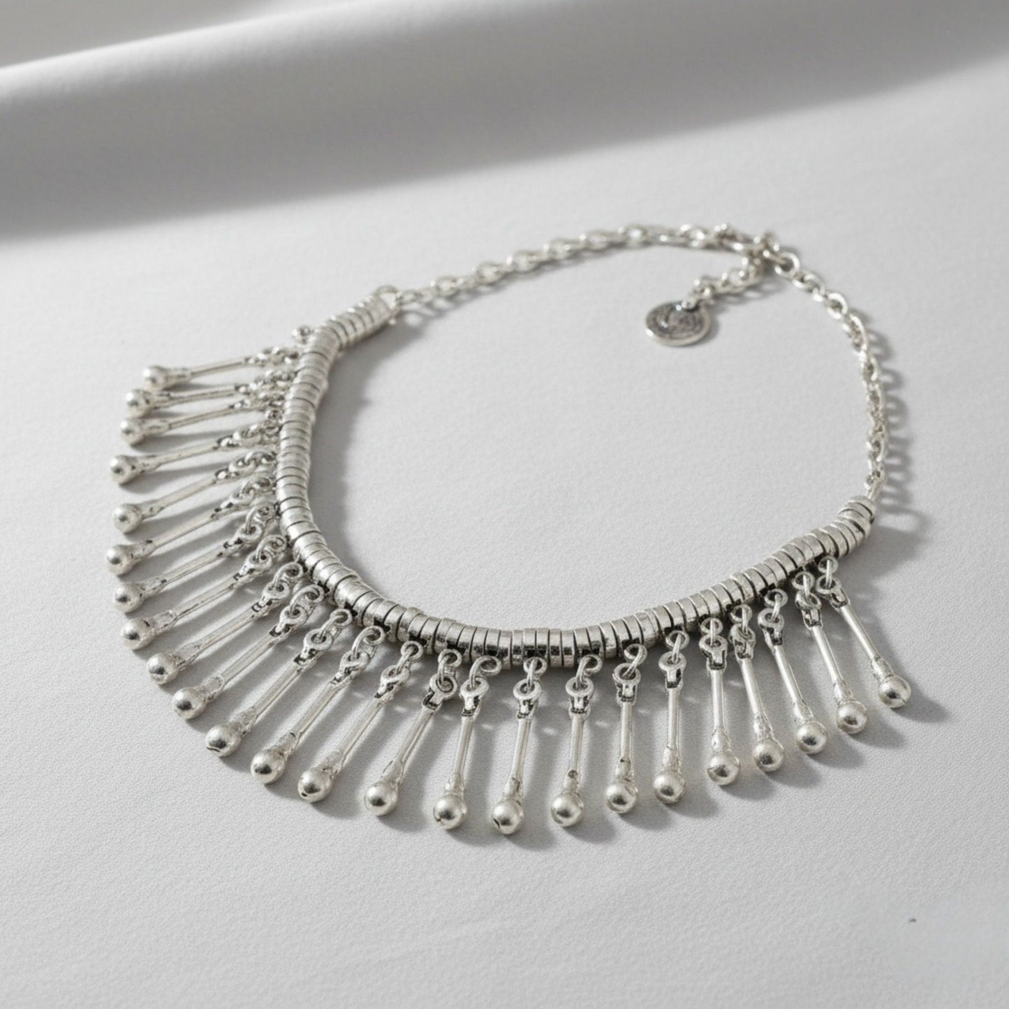 Detalle de los flecos de varillas plateadas con bolitas del collar de zamak étnico Joyería Osnor Zamak