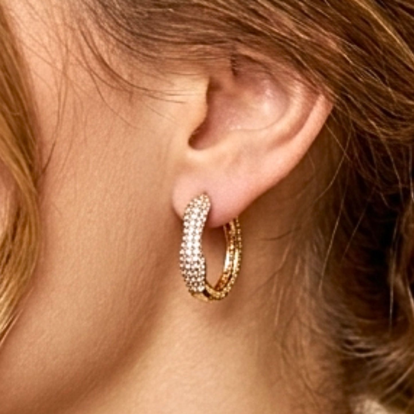 Chica luciendo Pendientes de acero inoxidable dorado chapado oro 14ktes diseño joyería osnor moda moderno mujer