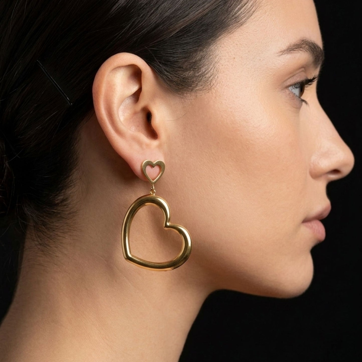 chica luciendo pendientes corazon acero dorado diseño joyeria osnor