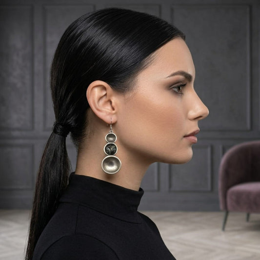 Mujer Luciendo Pendientes Zamak con Circonitas Grises - Tres Círculos Graduados. Joyeria Osnor