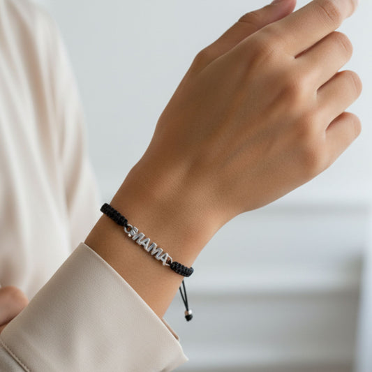 Mujer Luciendo Pulsera Mamá Plata con Hilo Negro Trenzado – Ajustable- Joyeria Osnor