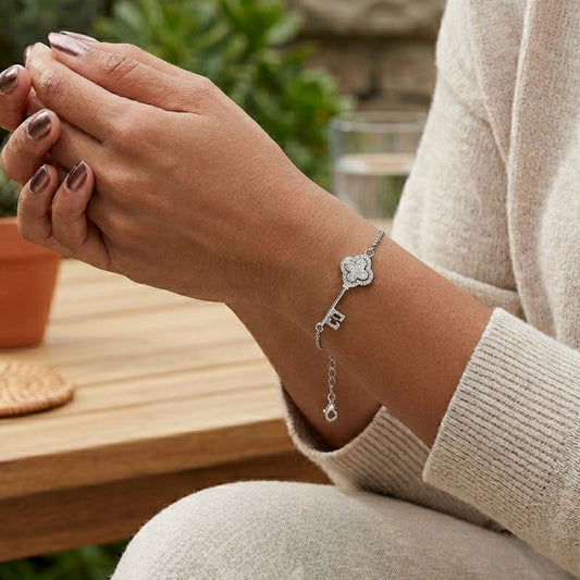 Mujer Luciendo Pulsera Doble Cadena Colgante Llave Trébol en Plata con Rodio y Circonitas. Joyeria Osnor