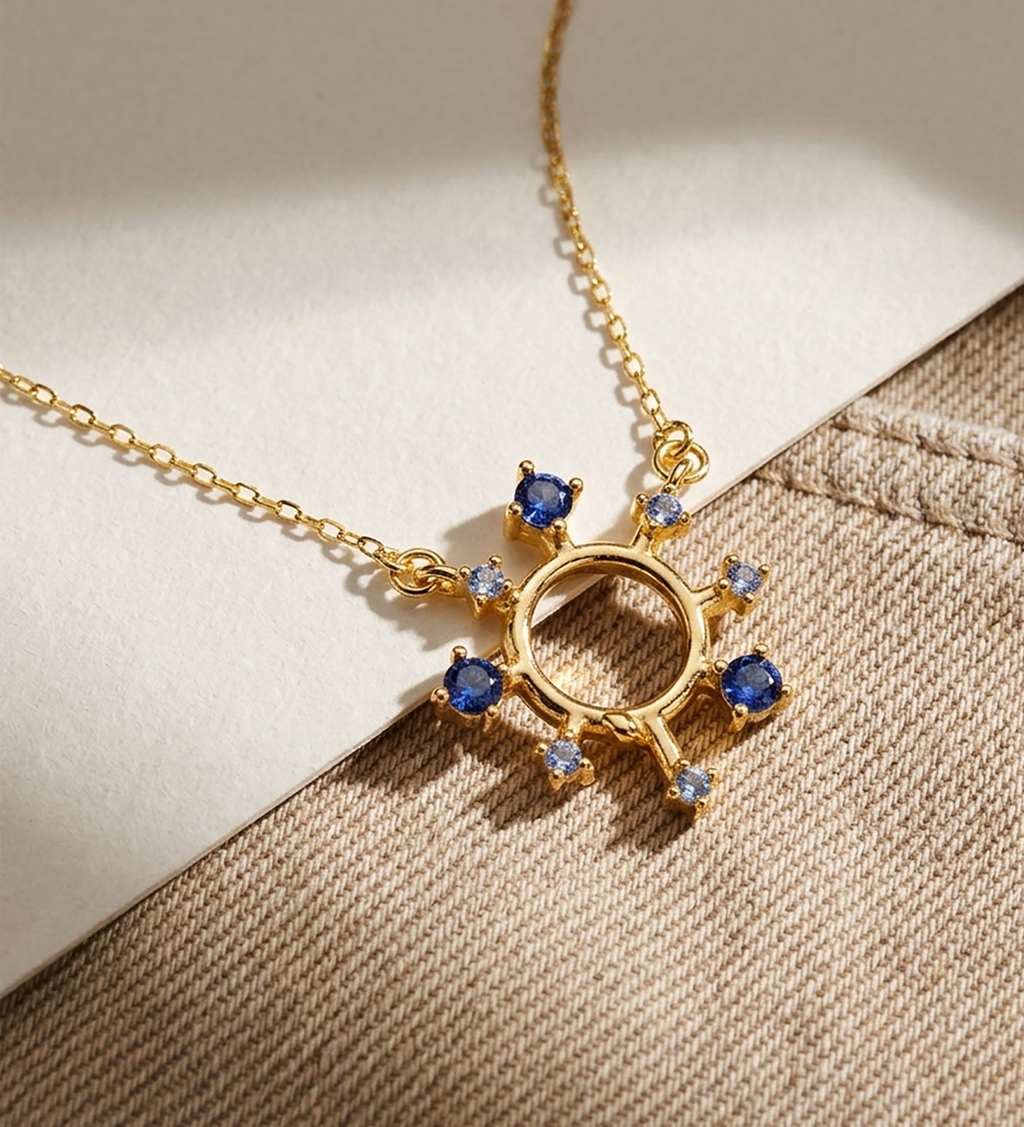 18K COLGANTE ORO AMARILLO RAYOS DE SOL Y CIRCONITAS AZULES 17X16 MM. CADENA FORZADA: 40-2 CM