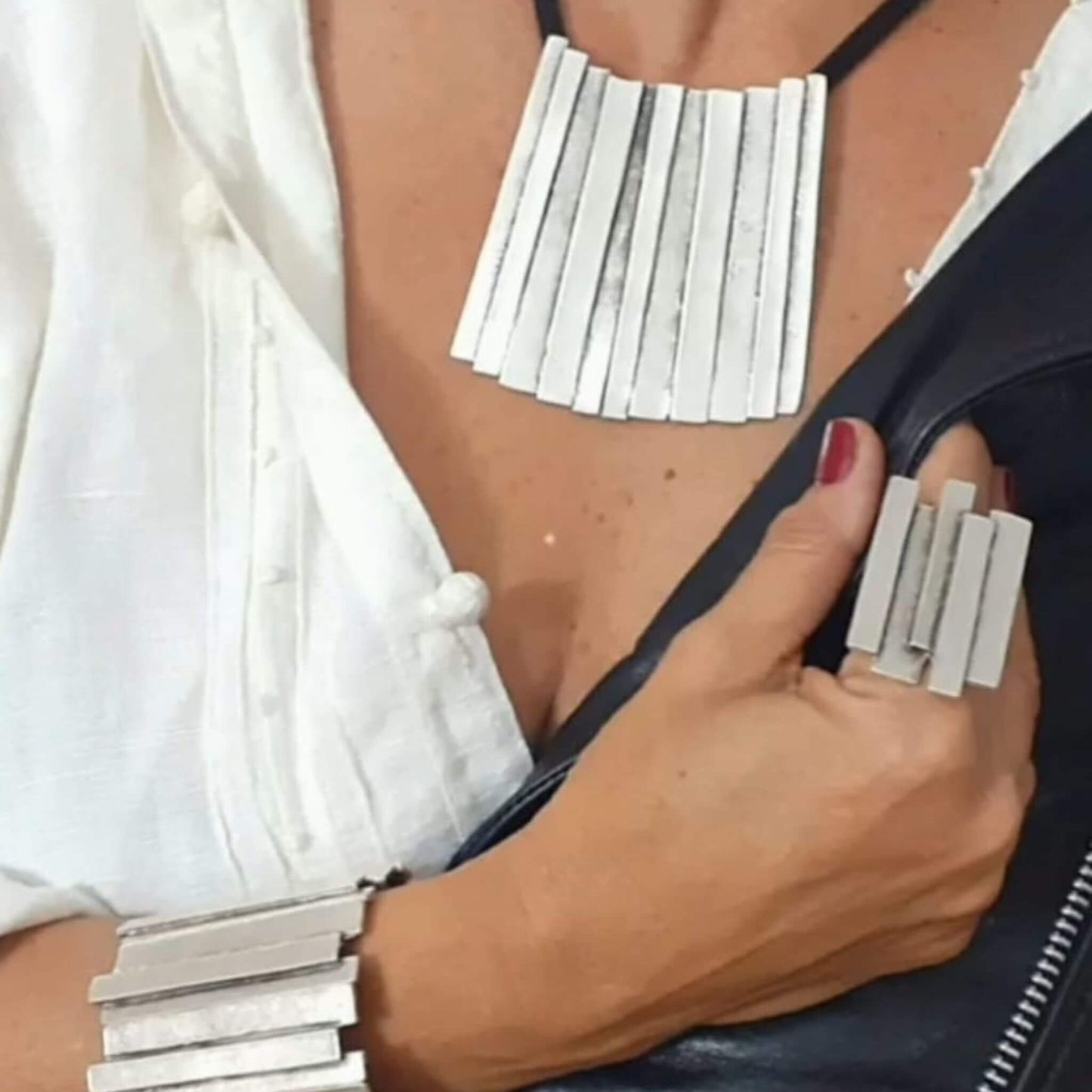 Chica luciendo collar anillo brazalete  zamak exclusivo colgante geometrico cadena de rejilla negra joyeria osnor