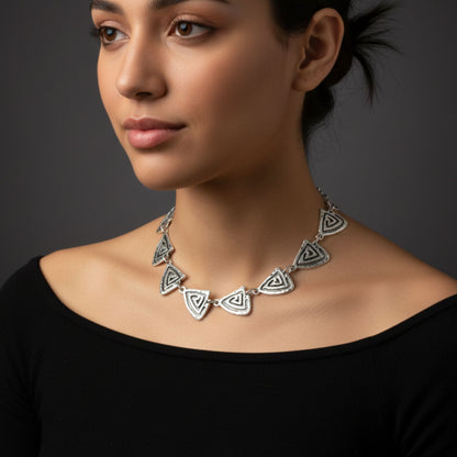 Modelo con collar zamak plateado triángulos geométricos, estilo étnico contemporáneo - Joyería Osnor Zamak