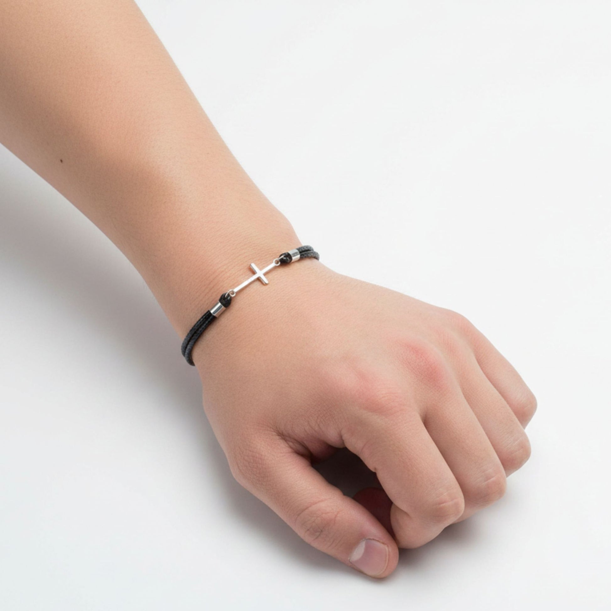 Hombre Luciendo Pulsera Cordón Negro Trenzado con Cruz de Plata Rodio. Joyeria Osnor