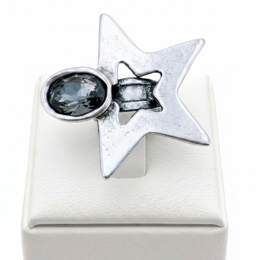 Anillo Zamak estrella 6 puntas con circonita gris ovalada sobre expositor de madera, Joyería Osnor Zamak