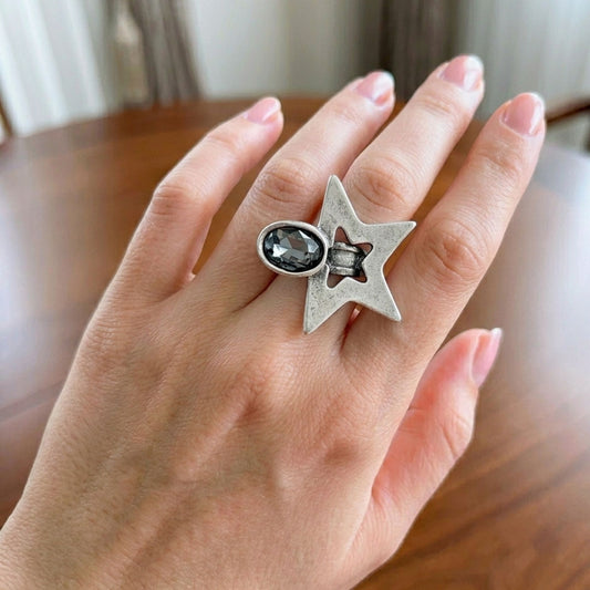 Modelo luciendo anillo Zamak estrella con circonita gris ovalada ajustable, diseño celestial glamour plateado, Joyería Osnor Zamak