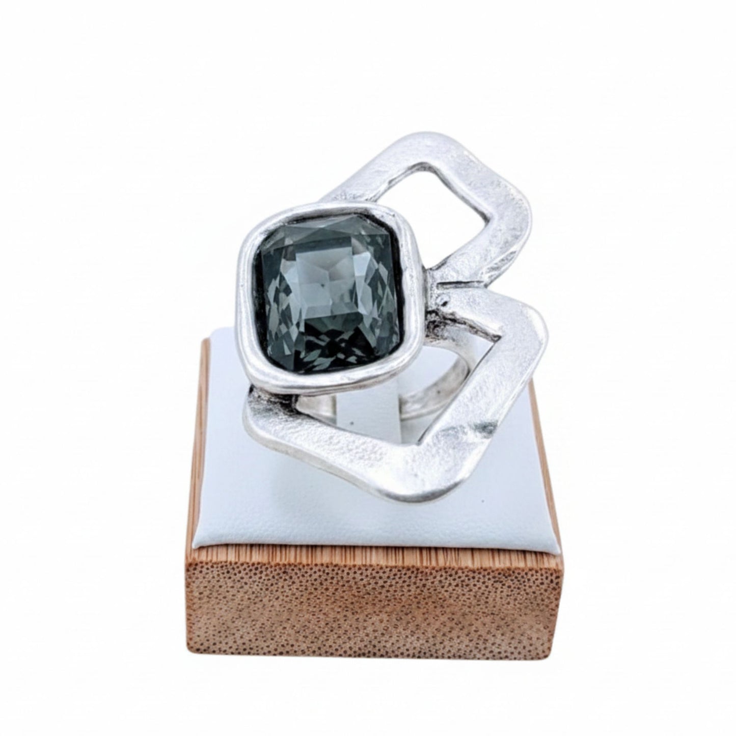 Anillo Zamak con circonita gris cushion-cut  sobre expositor de madera, Joyería Osnor Zamak