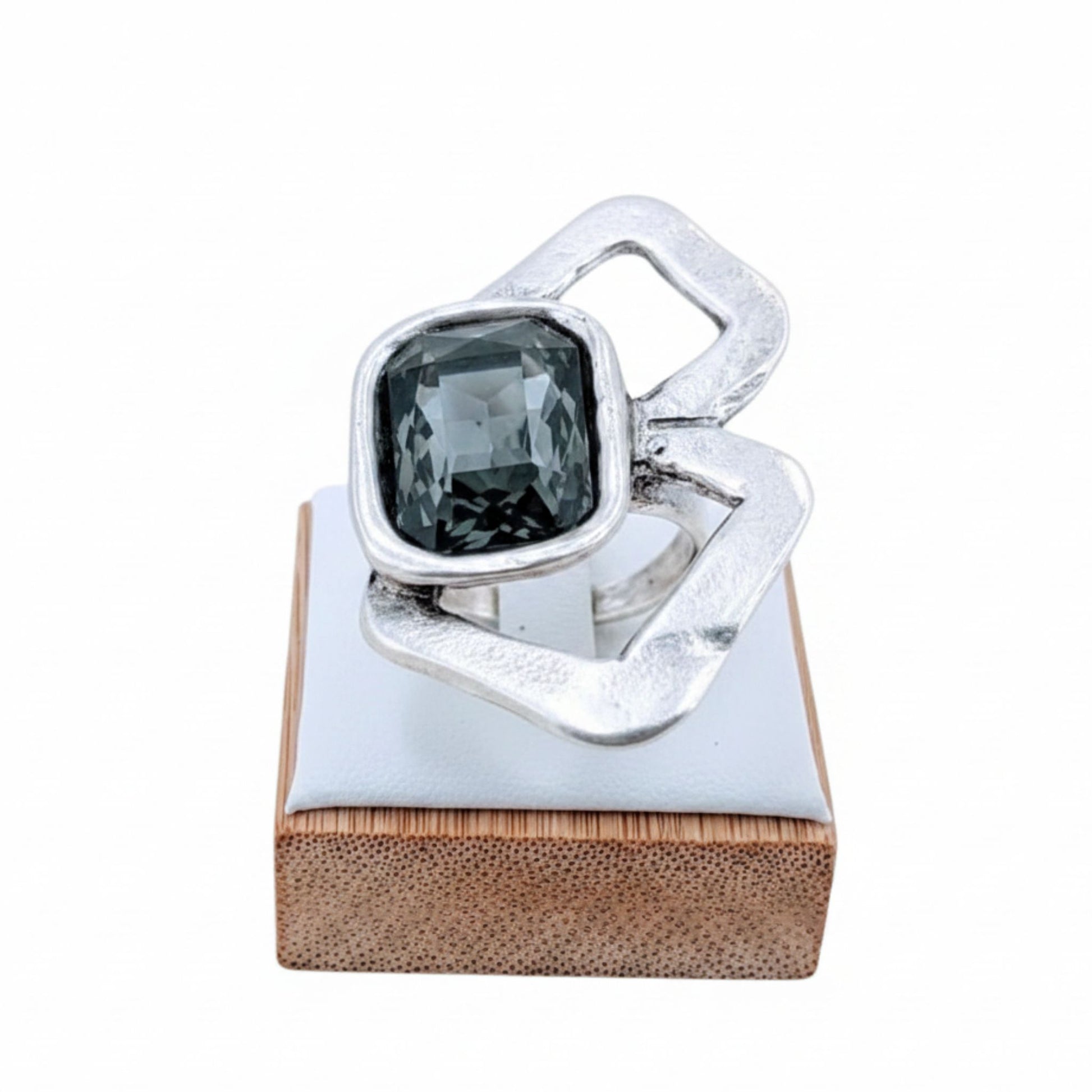 Anillo Zamak con circonita gris cushion-cut  sobre expositor de madera, Joyería Osnor Zamak