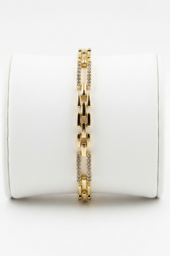Brazalete dorado en expositor blanco