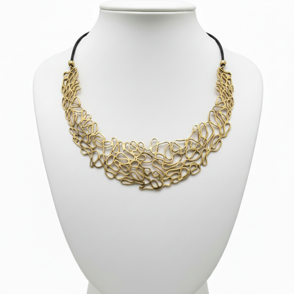 Collar dorado en expositor blanco