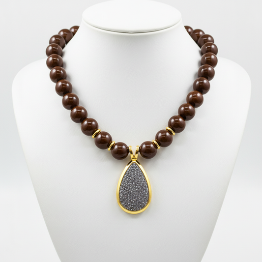 Collar en expositor blanco bolas marron acero dorado diseño joyeria osnor colgante gota