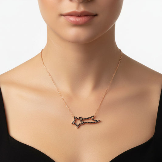 Mujer Luciendo Collar Estrella Fugaz Plata con Acabado Oro Rosa y Circonitas Negras. Joyeria Osnor
