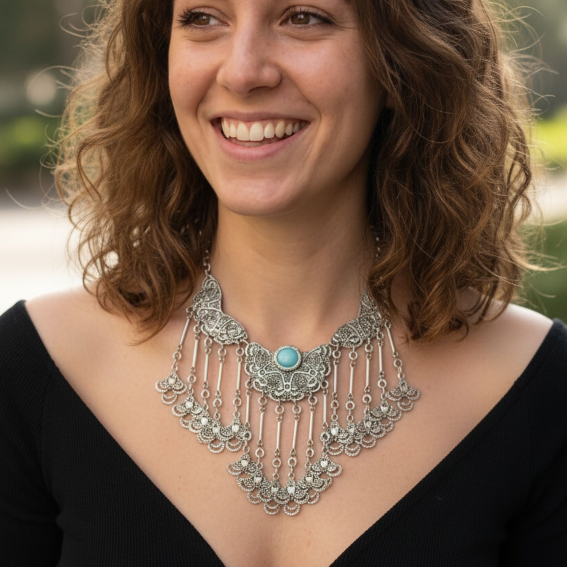 Collar de filigrana en zamak plateado con piedra turquesa, puesto en modelo, diseño étnico bohemio- Joyería Osnor Zamak