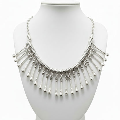 Collar babero de zamak plateado mujer con flecos de varillas y bolitas en cascada, estilo étnico Joyería Osnor Zamak