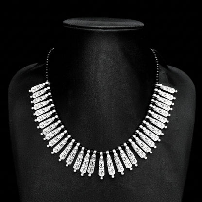 Collar bib de flecos en zamak plateado con piedras negras - Joyería Osnor Zamak