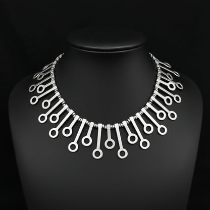 expositor luciendo collar unisex de zamak joyeria osnor zamak