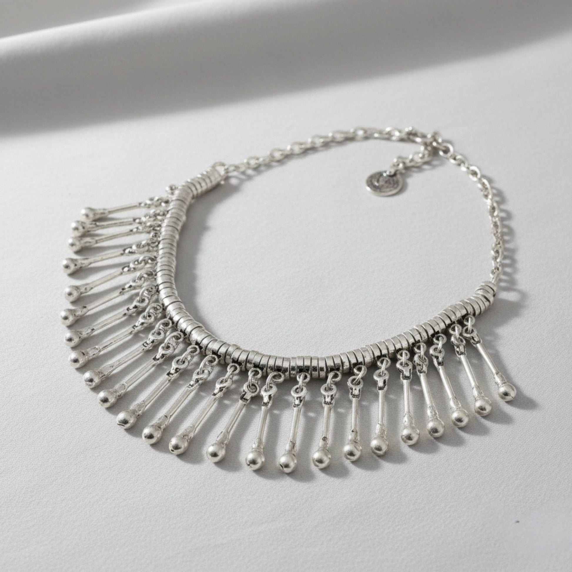 Detalle de los flecos de varillas plateadas con bolitas del collar de zamak étnico Joyería Osnor Zamak