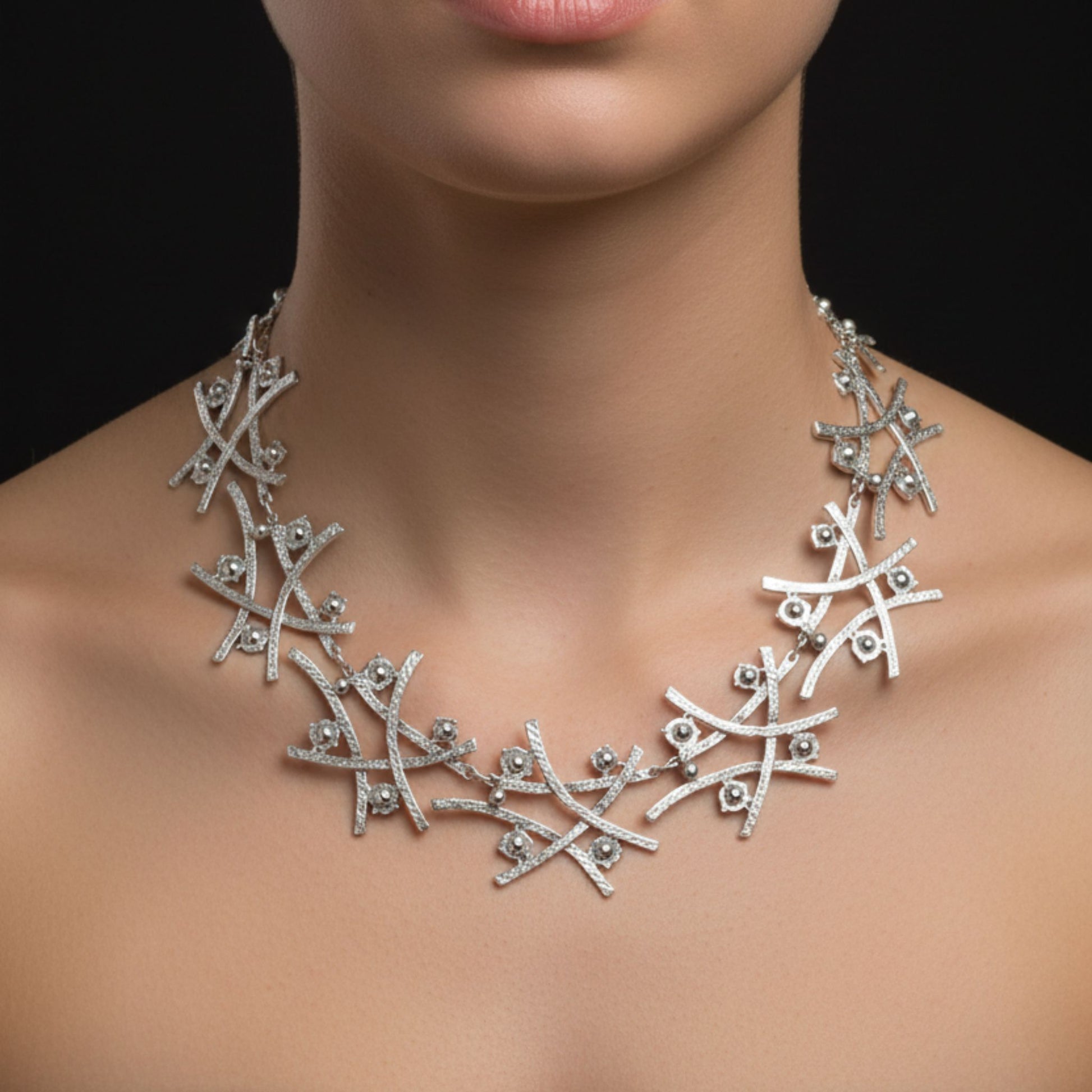 Mujer luciendo collar de zamak plateado con diseño de ramas entrelazadas
