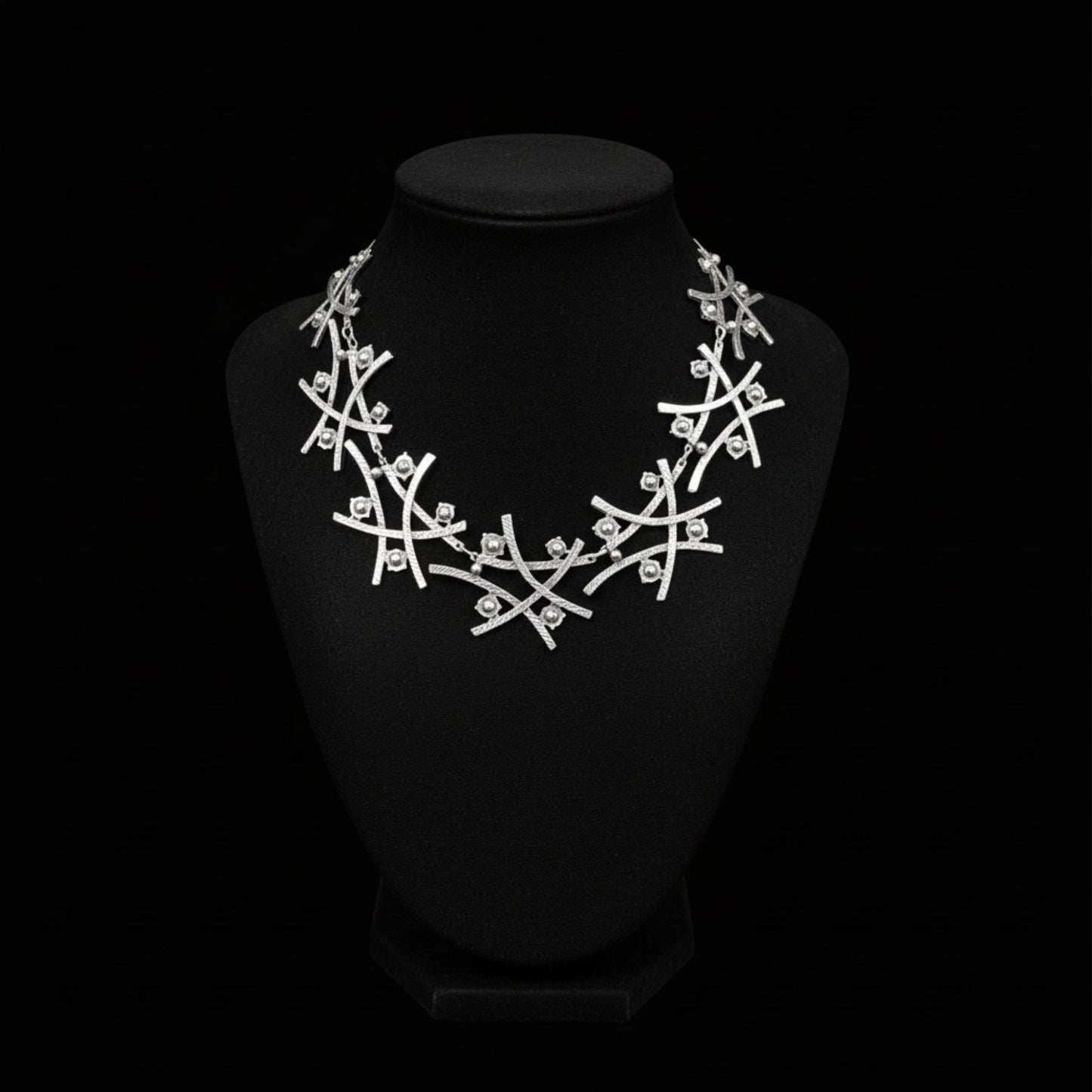 Collar de zamak plateado con diseño de ramas entrelazadas y detalles esféricos
