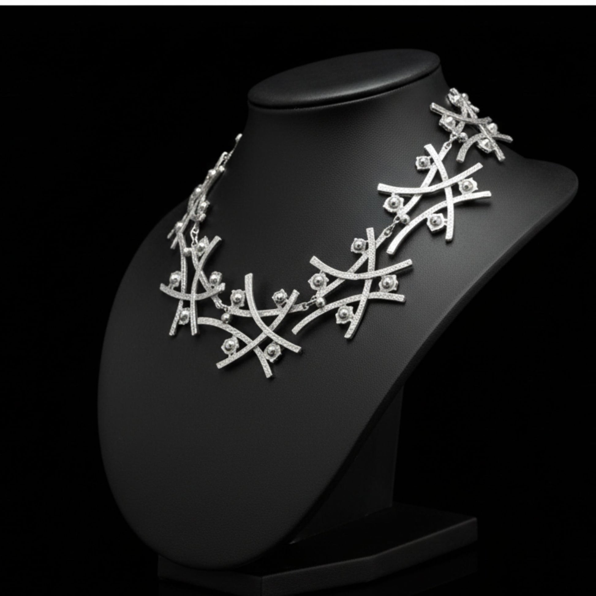 Collar de zamak plateado con diseño de ramas entrecruzadas y esferas decorativas
