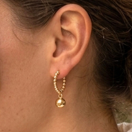 Chica luciendo Pendientes de acero inoxidable dorado chapado oro 14ktes diseño de joyería Osnor 
