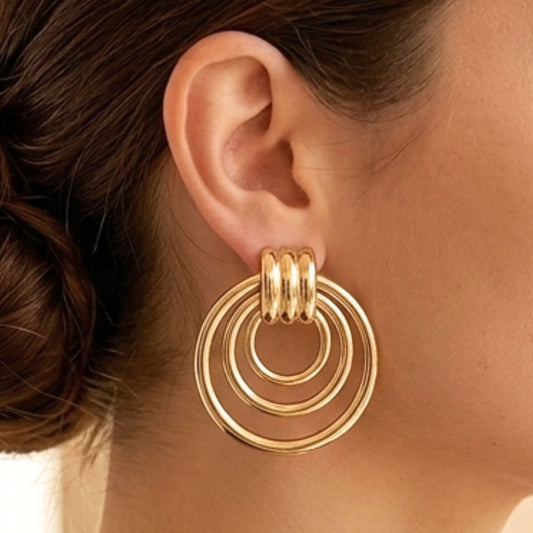 Chica luciendo Pendientes de acero inoxidable dorado chapado oro 14ktes diseño joyería osnor 