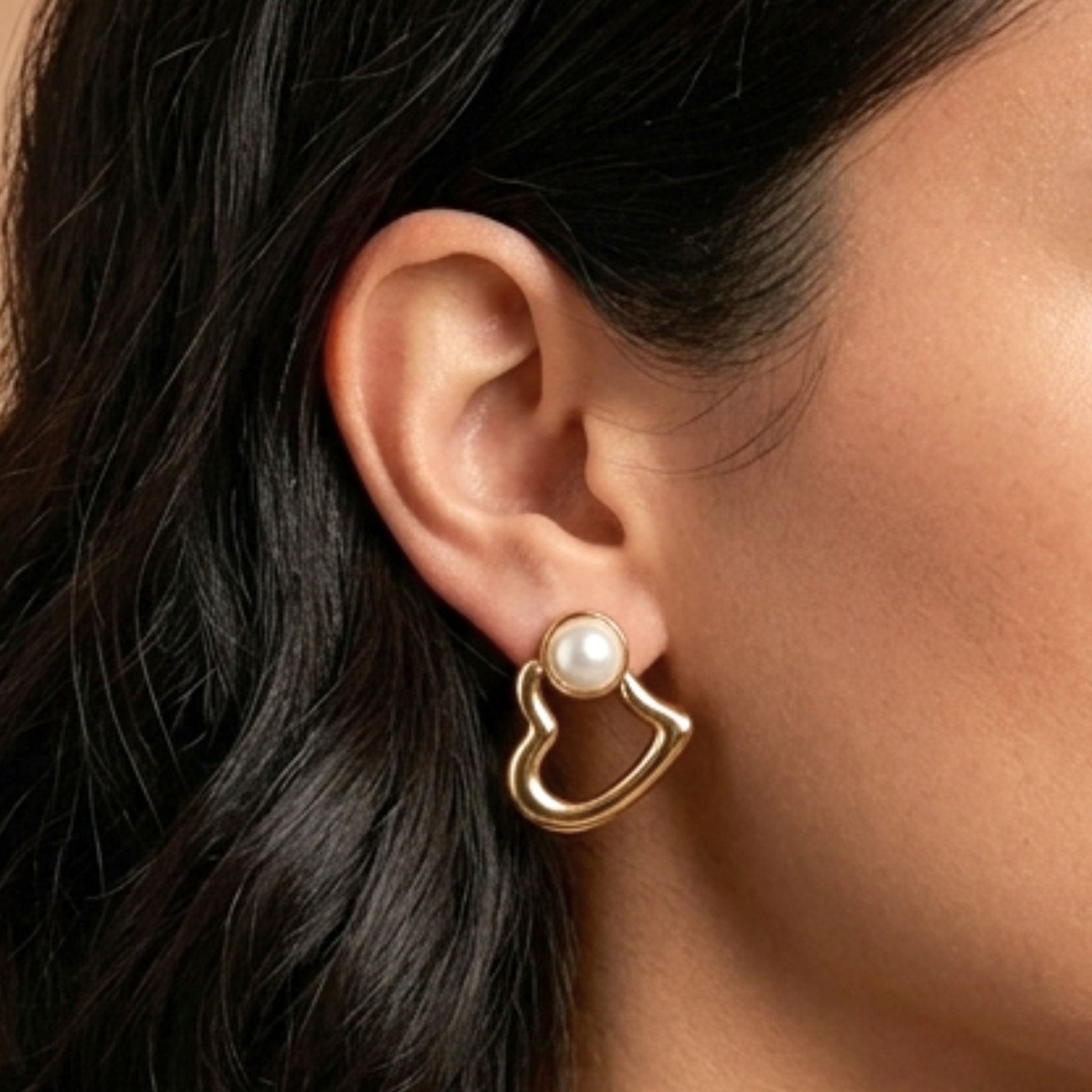 Chica luciendo Pendientes acero inoxidable dorado chapado oro 14ktes Perla liso brillo corazón volumen largos diseño mujer joyería osnor moda moderno elegante boda fiesta glamour lujo 