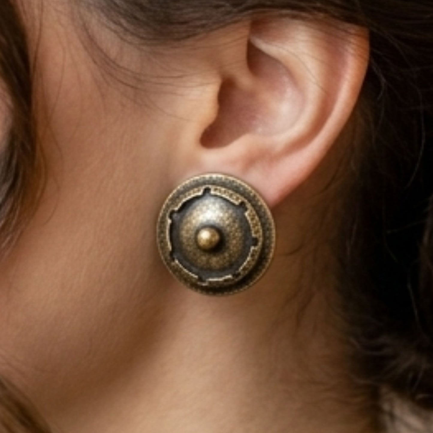 chica luciendo pendientes de bronce redondo esculura joyeria osnor zamak