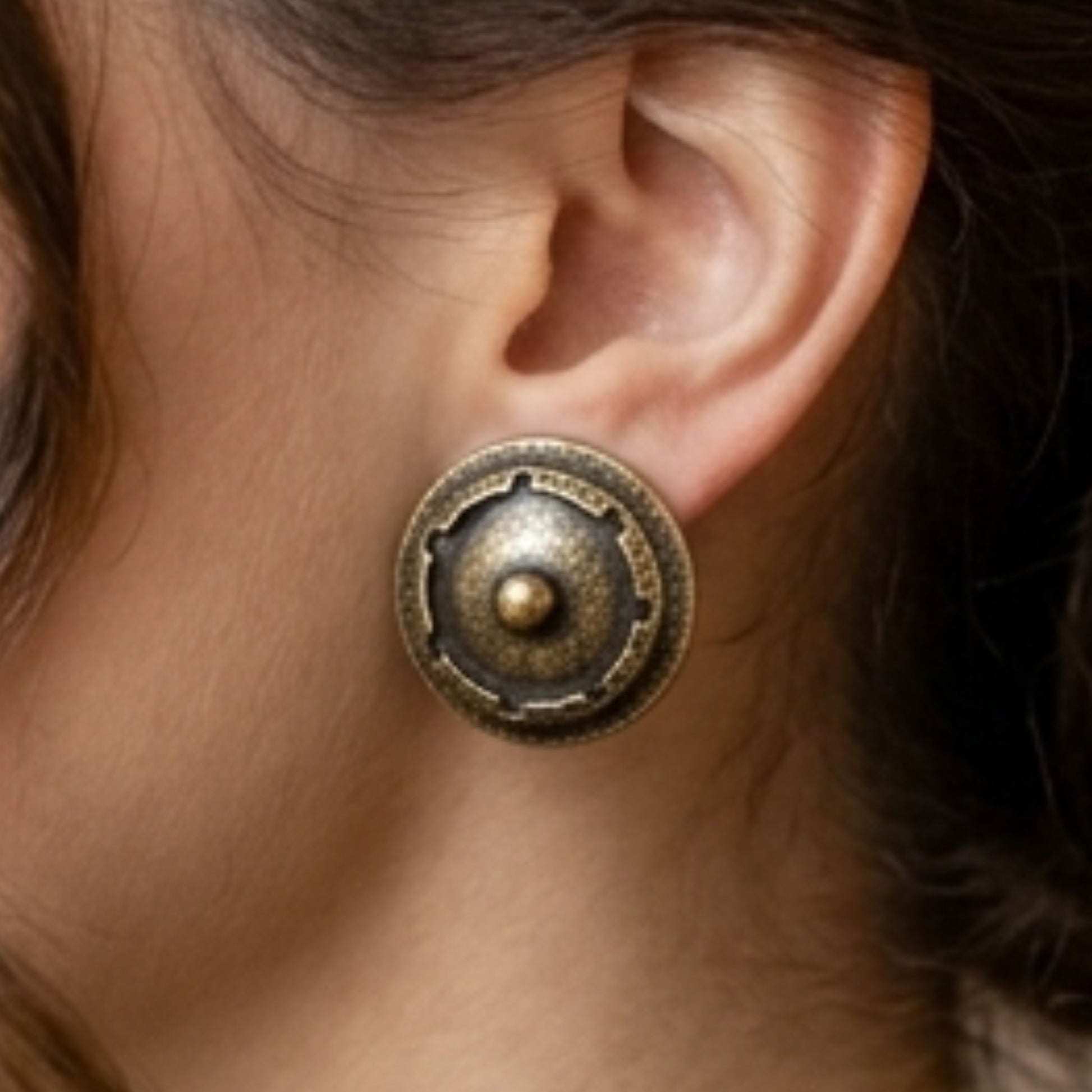 chica luciendo pendientes de bronce redondo esculura joyeria osnor zamak