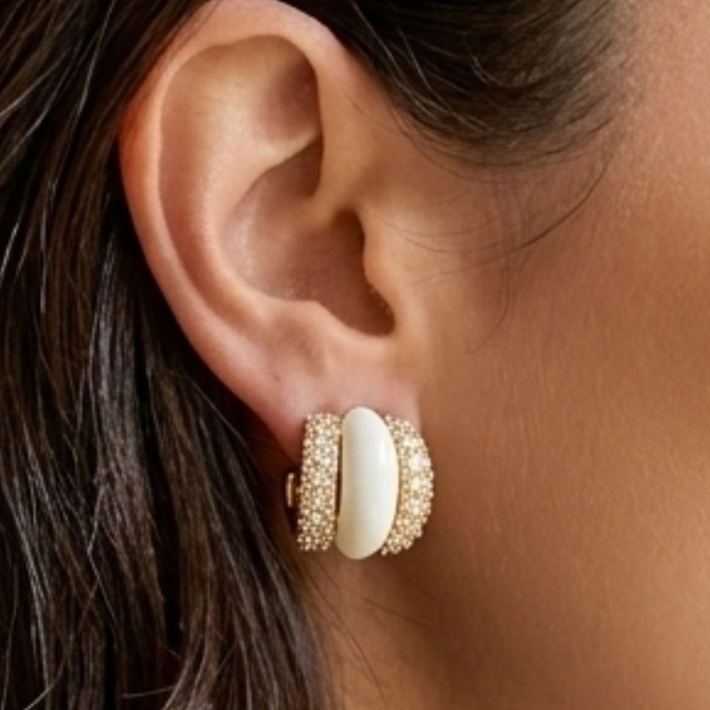 chica luciendo pendientes acero dorado ceramica blanca circonitas diseño joyeria osnor