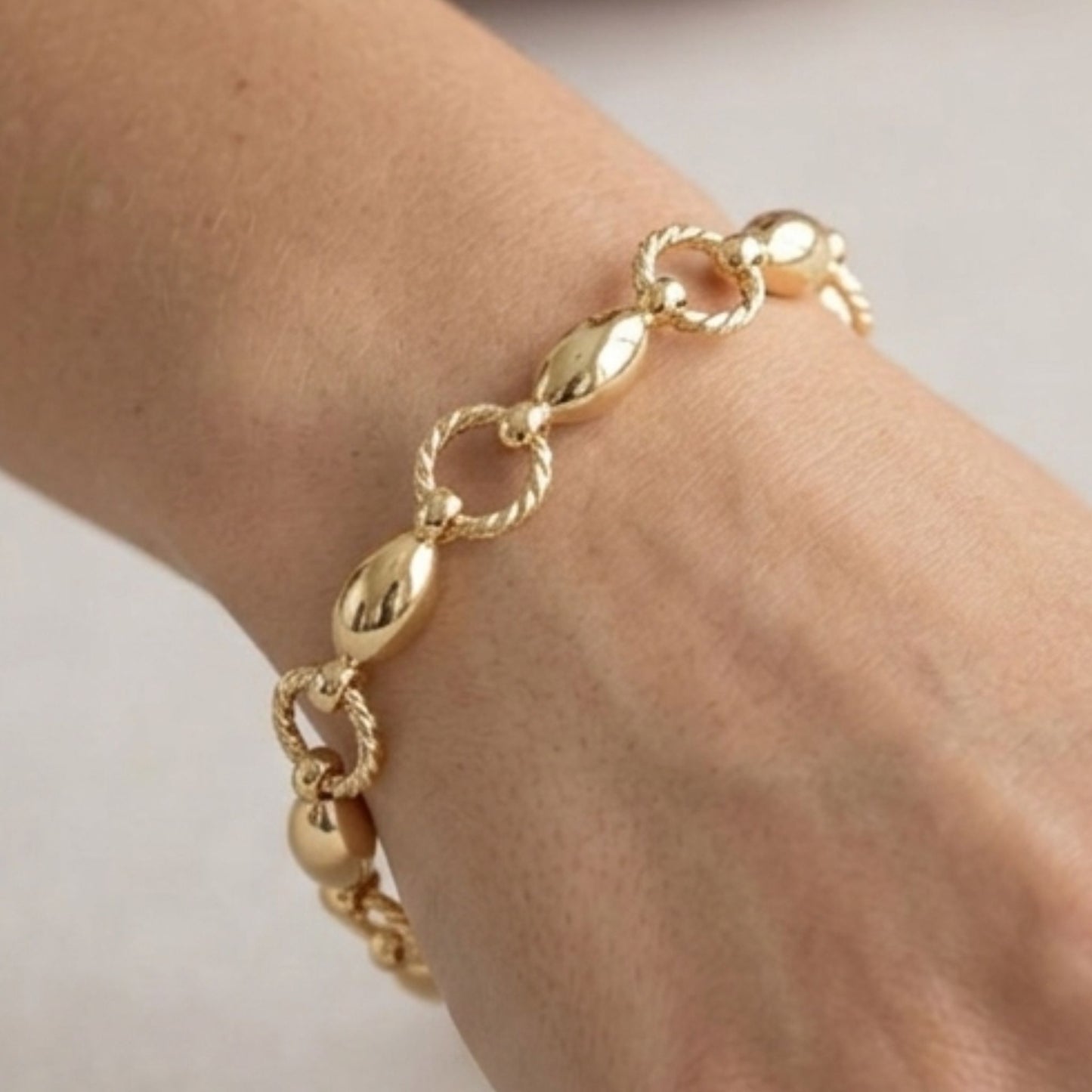 Chica luciendo pulsera de acero inoxidable dorado chapado oro 14ktes diseño joyería osnor 