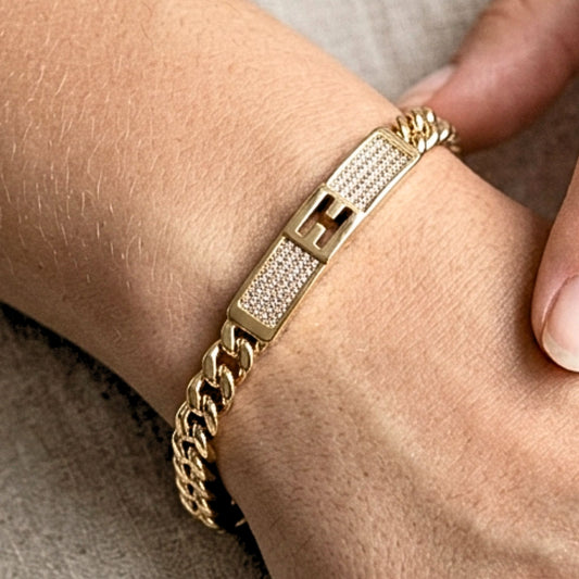 Chica luciendo pulsera brazalete acero inoxidable dorado chapado oro 14ktes circonitas blancas engastadas diseño joyería osnor moda 
