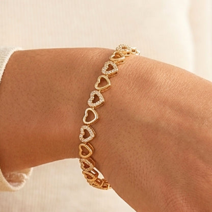 Chica luciendo pulsera de acero inoxidable dorado chapado oro 14ktes circonitas blancas engastadas diseño joyería osnor corazón 