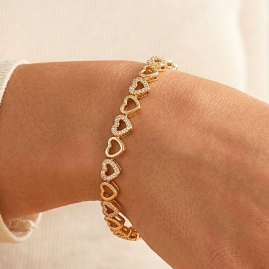 Chica luciendo pulsera de acero inoxidable dorado chapado oro 14ktes circonitas blancas engastadas diseño joyería osnor corazón 