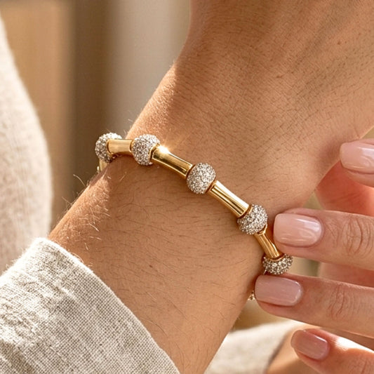 Chica luciendo pulsera de acero inoxidable dorado chapado oro 14ktes circonitas blancas engastadas diseño joyería moda moderno elegante boda fiesta fashion glamour lujo 