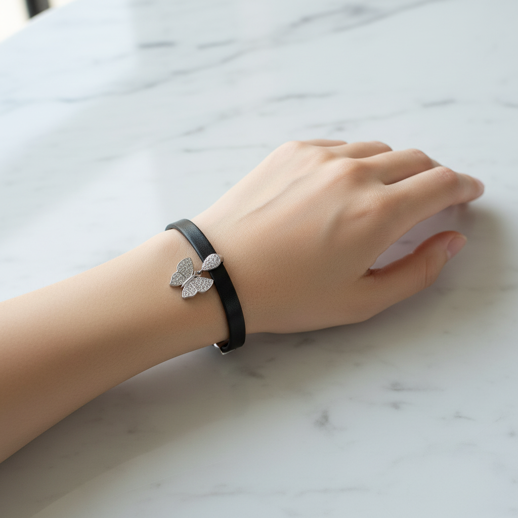 Mujer Luciendo Pulsera de Caucho Negro con Mariposa de Plata y Circonitas. Joyeria Osnor