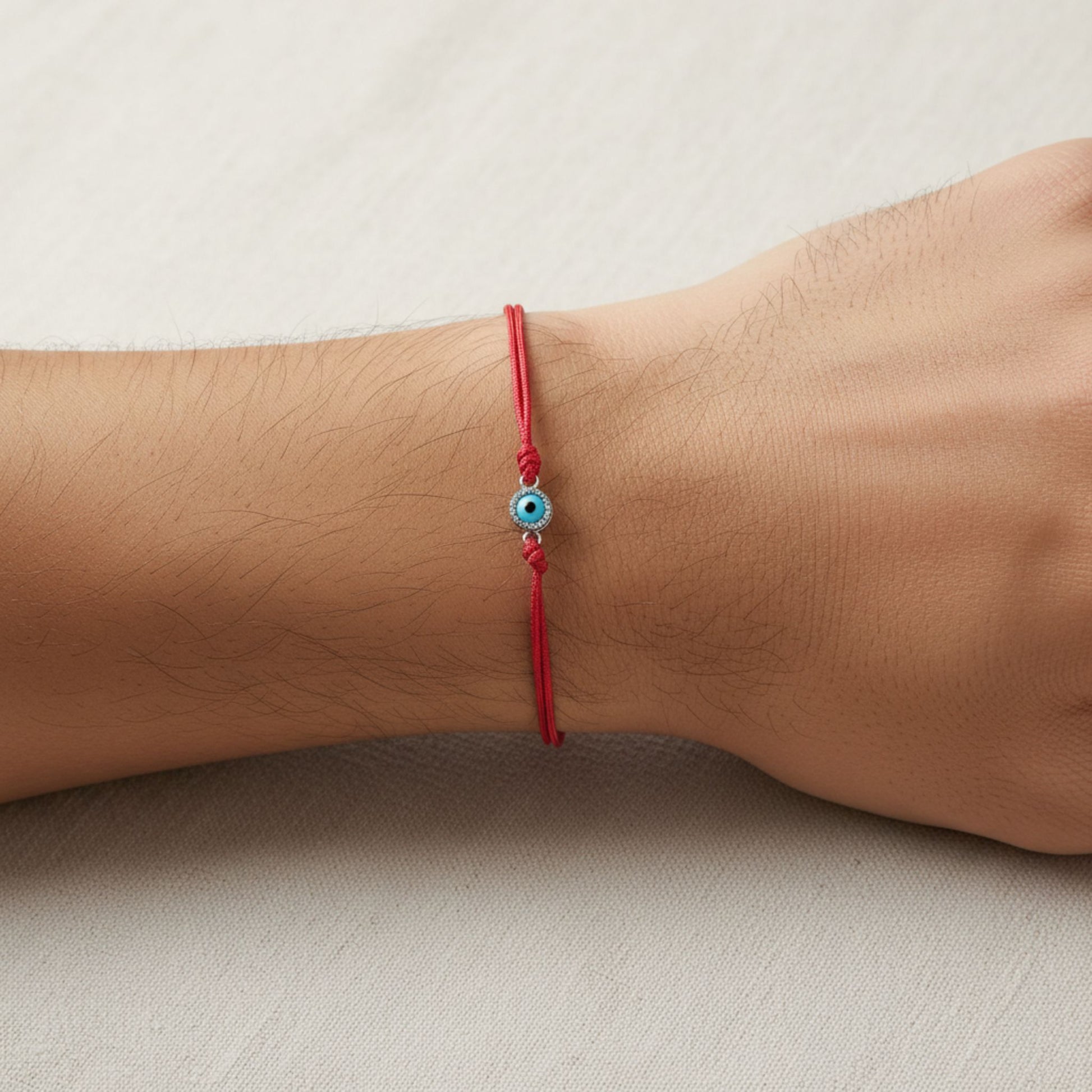Hombre Luciendo Pulsera de Hilo Rojo Ajustable con Ojo Turco de Plata – Unisex. Joyeria Osnor