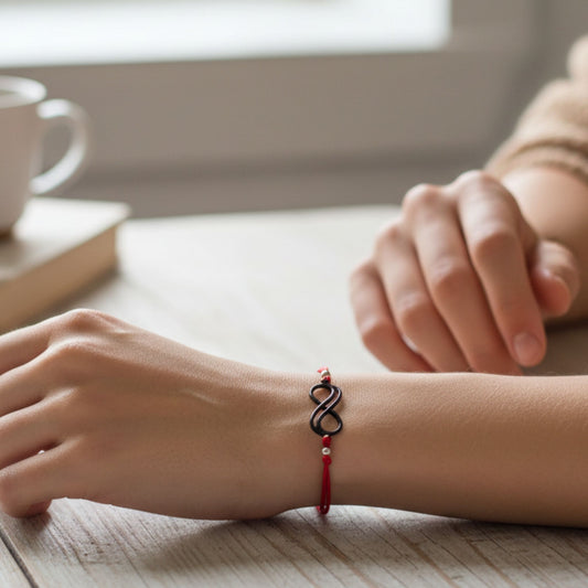 Mujer Luciendo Pulsera Hilo Rojo Doble con Infinito Negro Rutenio Unisex. Joyeria Osnor
