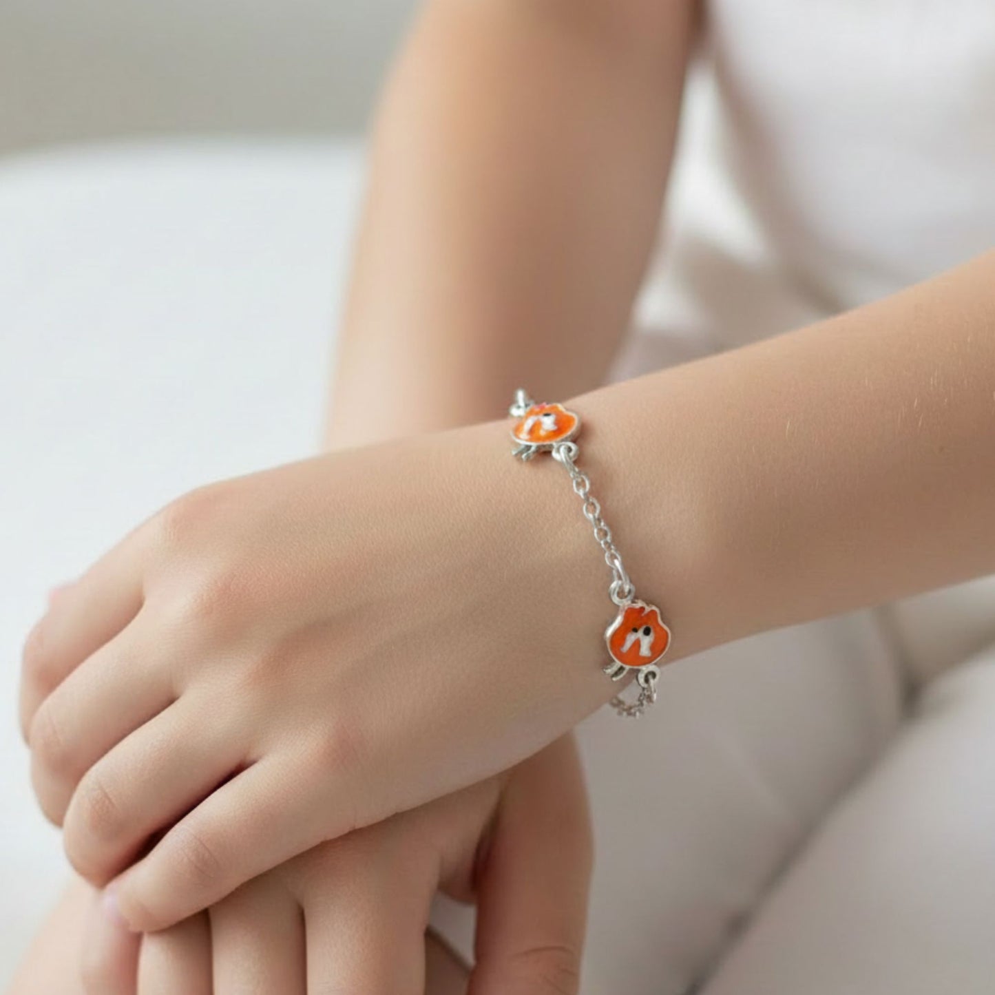 Niña Luciendo Pulsera Infantil Plata Charms Animal Esmalte Naranja. Joyeria Osnor