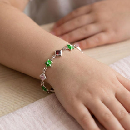 Niña Luciendo Pulsera Infantil Plata Estrellas Esmalte Verde y Circonitas Multicolor. Joyeria Osnor