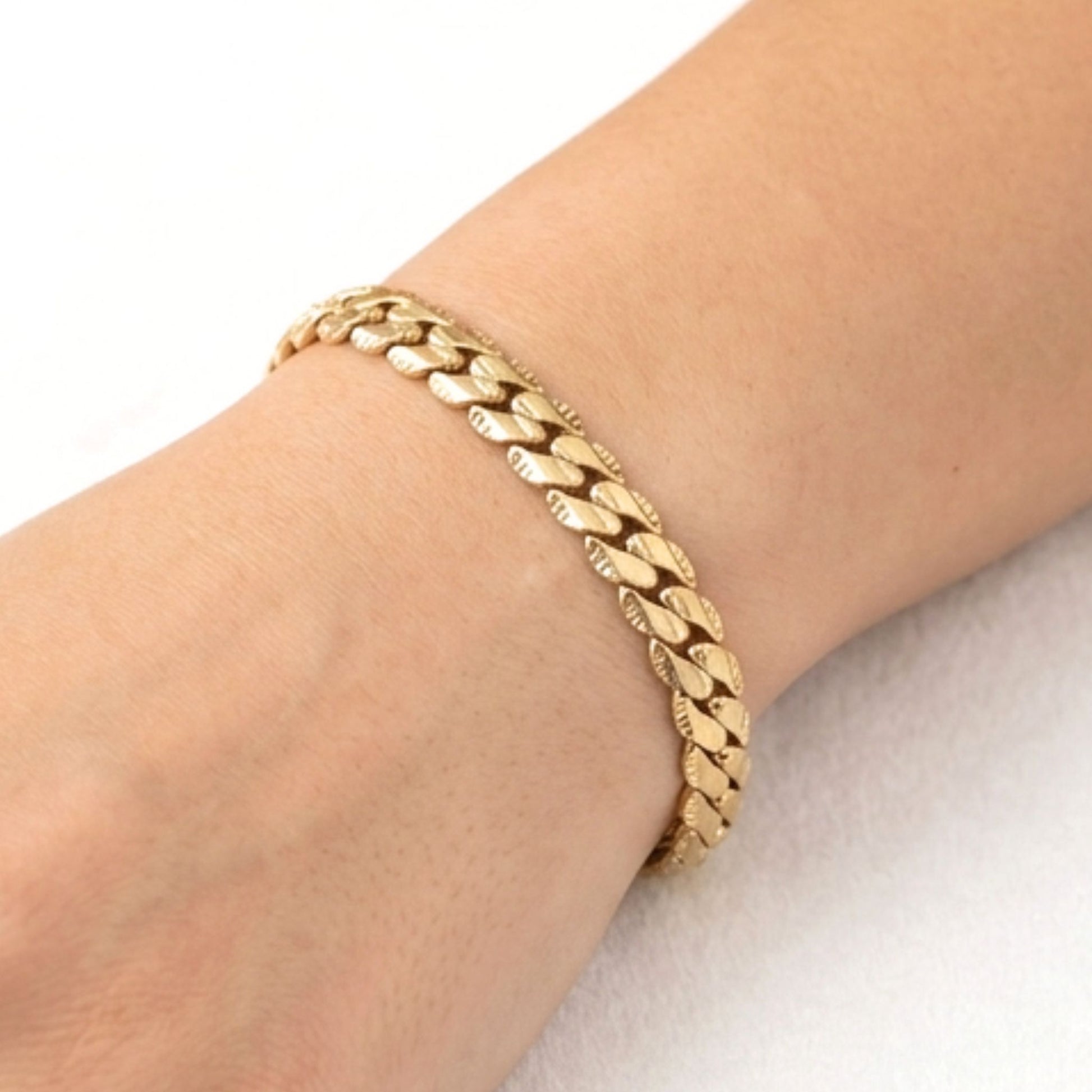 Chica luciendo pulsera de acero inoxidable dorado chapado oro 14ktes diseño joyería osnor moda 