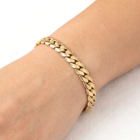 Chica luciendo pulsera de acero inoxidable dorado chapado oro 14ktes diseño joyería osnor moda 